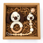 Handmade crochet puppy rattle and matching puppy pacifier holder in a kraft gift box