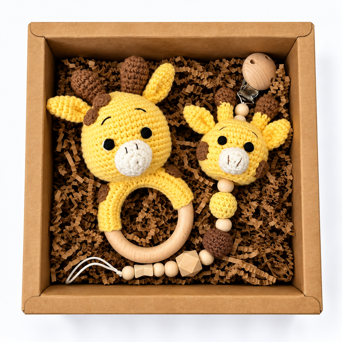 Handmade yellow crochet giraffe baby rattle and matching giraffe pacifier holder in kraft gift box