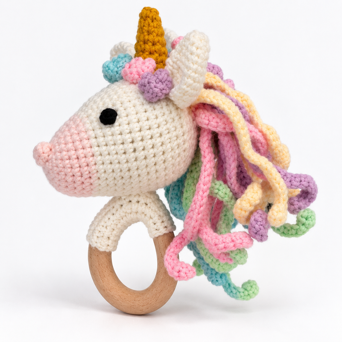 Side view of handmade crochet unicorn baby rattle showing rainbow mane and wooden ring